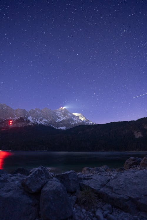 Free Body of Water Near Mountain during Night Time Stock Photo