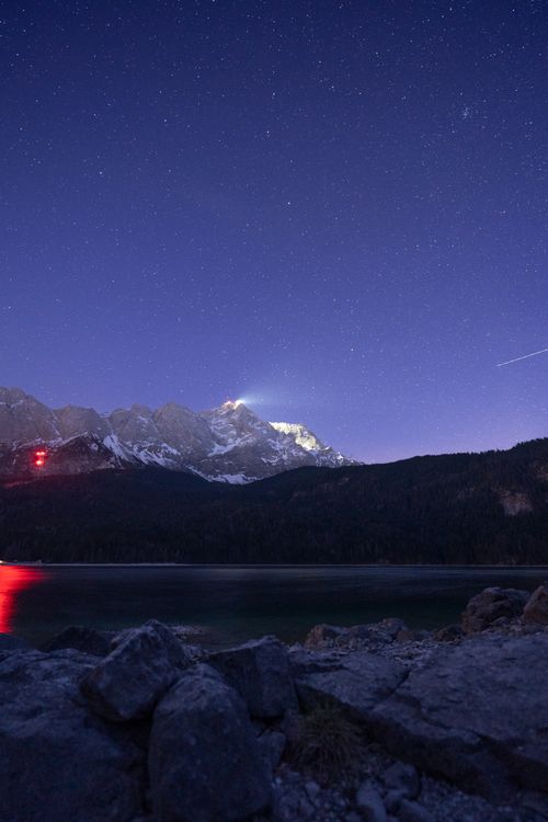 Free Breathtaking starry night sky over snow-capped mountains and lake in Grainau, Bavaria. Stock Photo