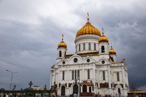 Free A striking view of Moscow's famous cathedral featuring its golden domes under a cloudy sky. Stock Photo