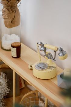 A vintage yellow rotary phone displayed on a wooden shelf adds a nostalgic touch to the interior decor.