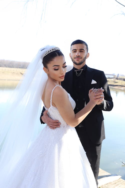 Man in Black Suit Jacket Dancing with  Woman in White Wedding Dress