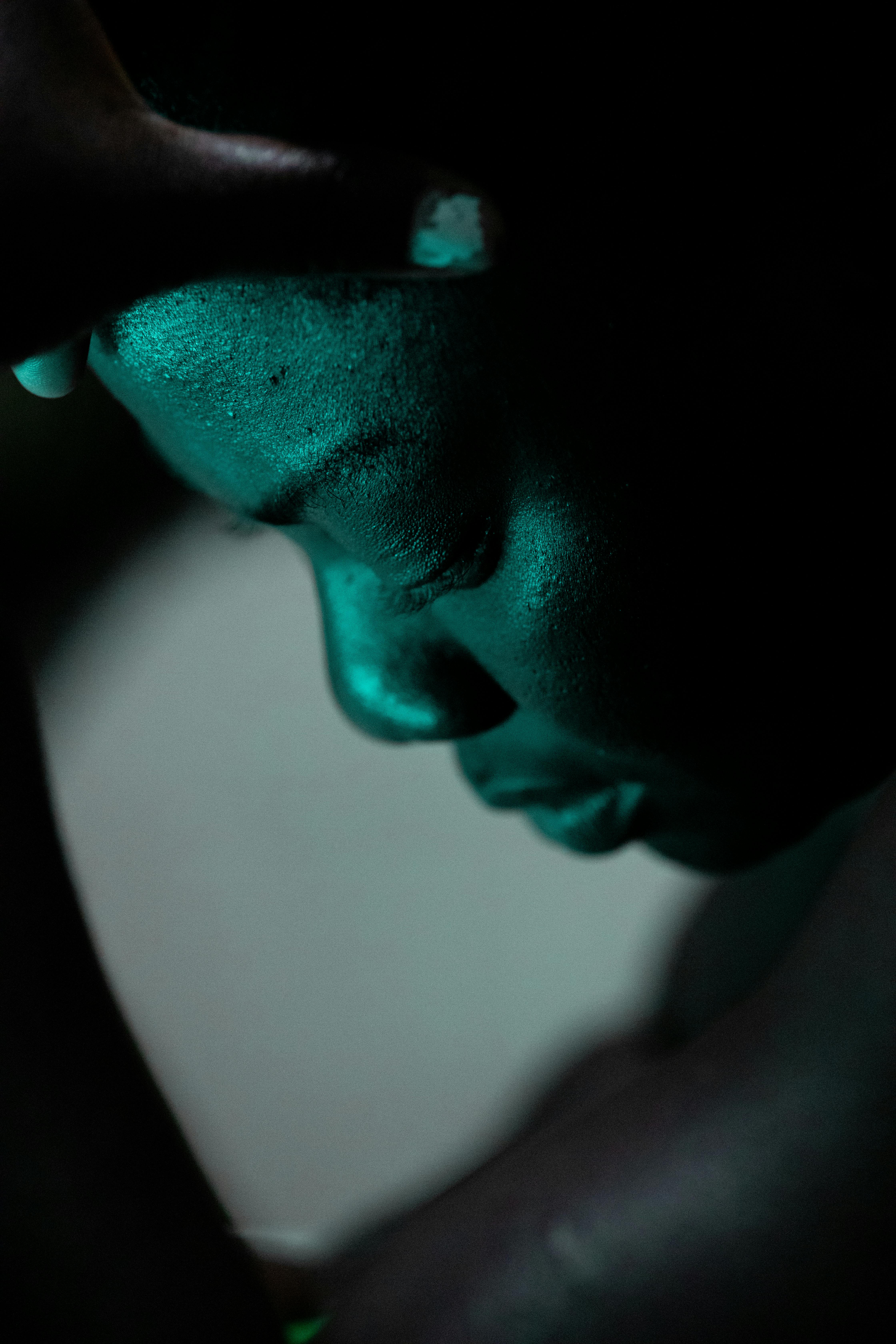 Dramatic low key portrait of a person, highlighting emotional expression.