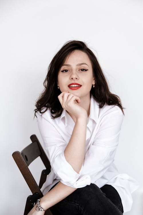 A Gorgeous Woman with Red Lips Posing with Her Hand on Chin