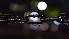 湿钢链在夜间拍摄的艺术镜头，背景是散景灯