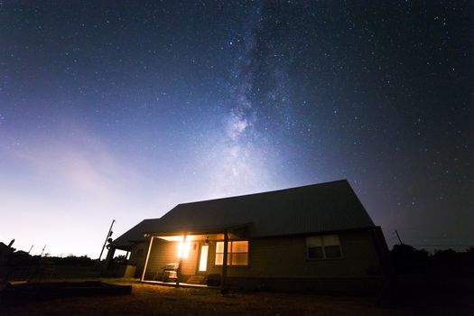 一座宁静的农舍在璀璨的银河夜空下熠熠生辉，非常适合观星爱好者