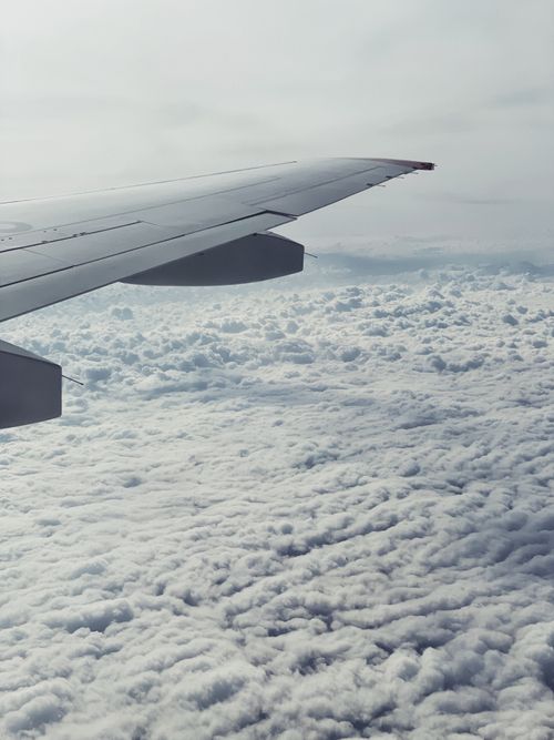 Free A calming view from an airplane window above fluffy white clouds, showcasing tranquility in flight. Stock Photo