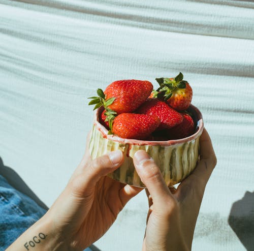 Person Holding a Bowl Filled With Strawberries