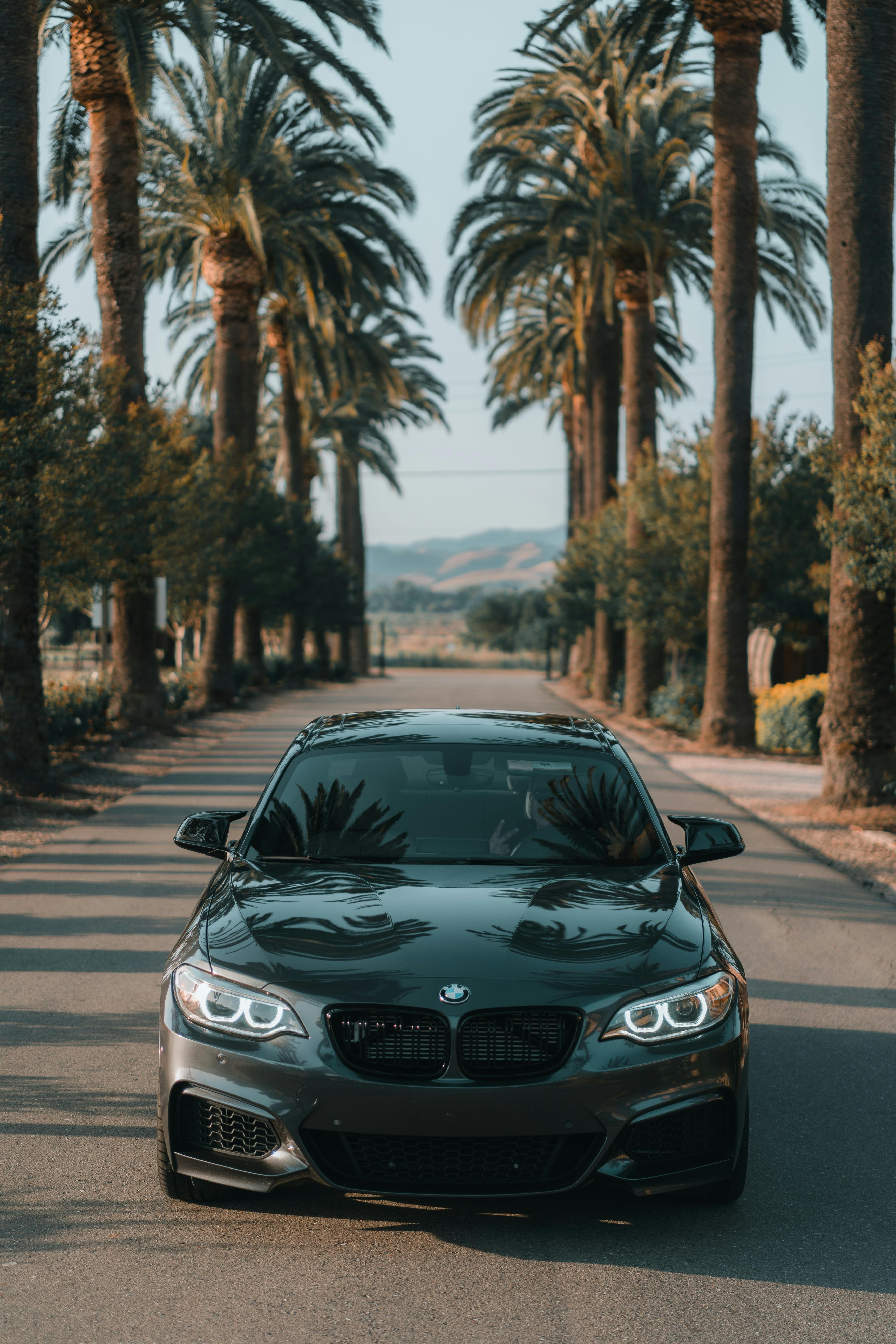 luxurious black car driving down empty street