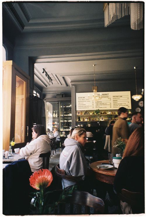 Free Customers inside a cozy café enjoying meals and drinks with ambient lighting. Stock Photo