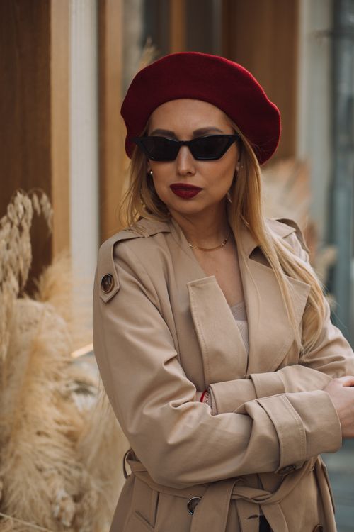 Free Chic woman wearing sunglasses and beret, standing elegantly in a street setting, exuding style. Stock Photo