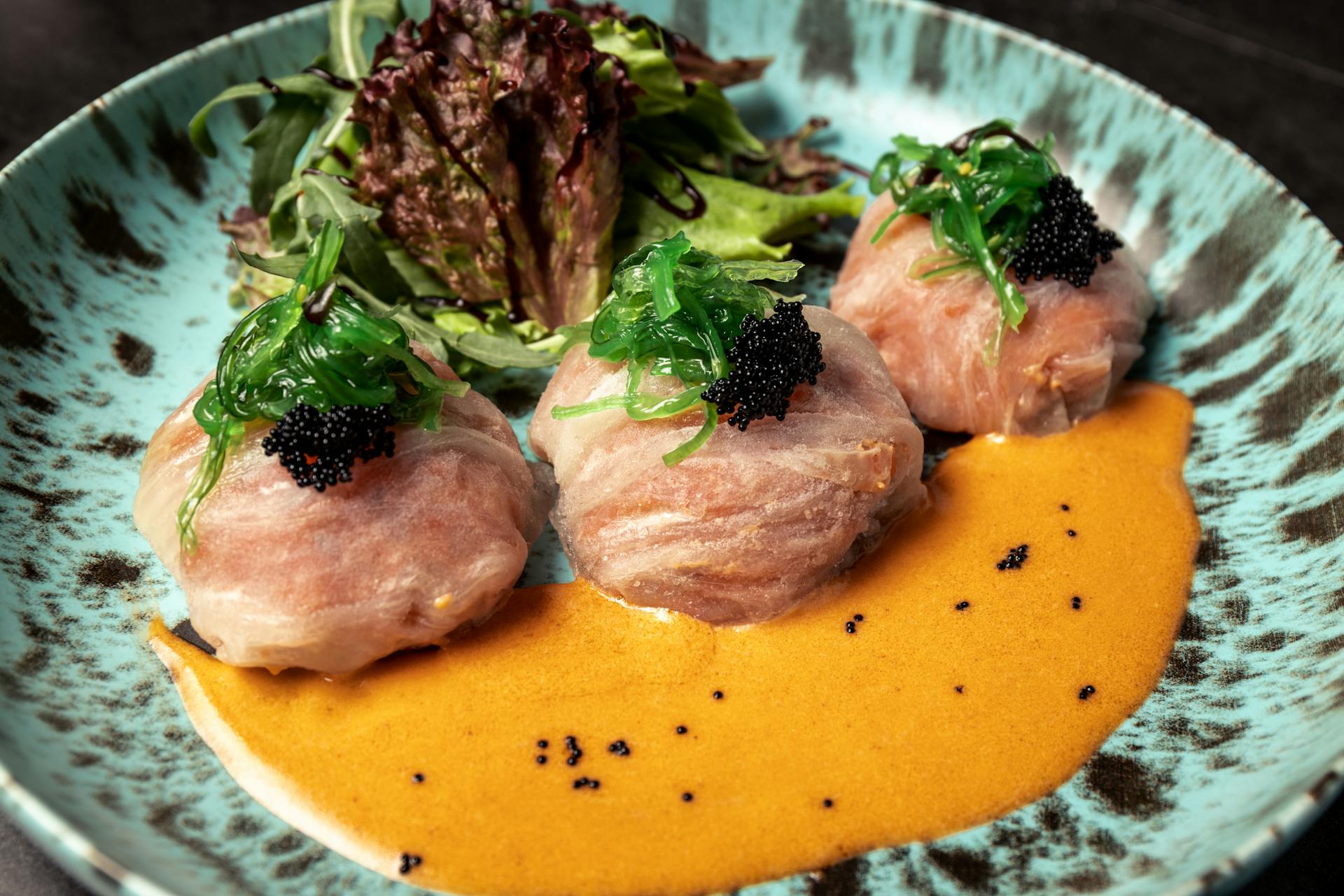 Delicately wrapped seafood with vibrant greens and sauce, perfect for gourmet experiences.