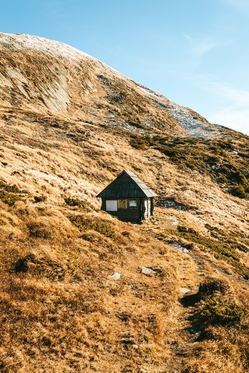 Free A solitary cabin nestled in the mountains of Romania during fall, offering a tranquil escape. Stock Photo