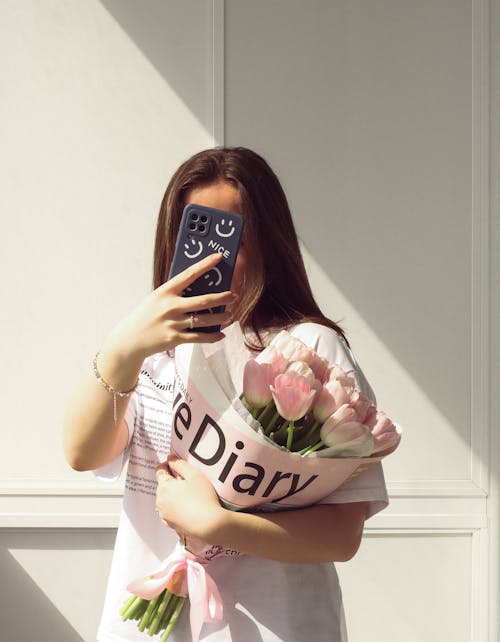Foto profissional grátis de buquê de flores, celular, holding