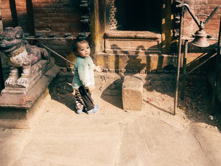 A Child Standing Near The Doorway