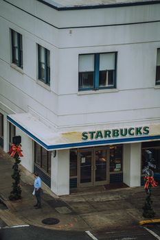 A street view of a corner Starbucks building decorated for the holidays.