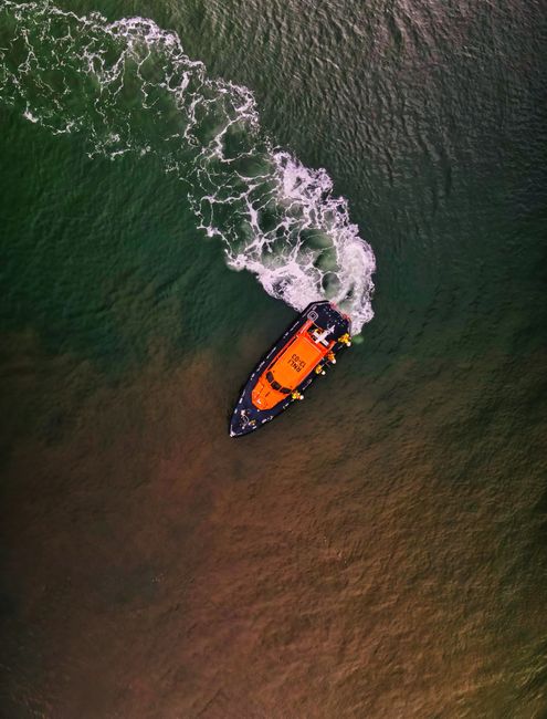 Drone shot capturing a lifeboat navigating the ocean near Exmouth, England.