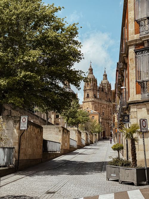 Free Picturesque cobblestone street leads to a historic cathedral in Salamanca, Spain. Stock Photo