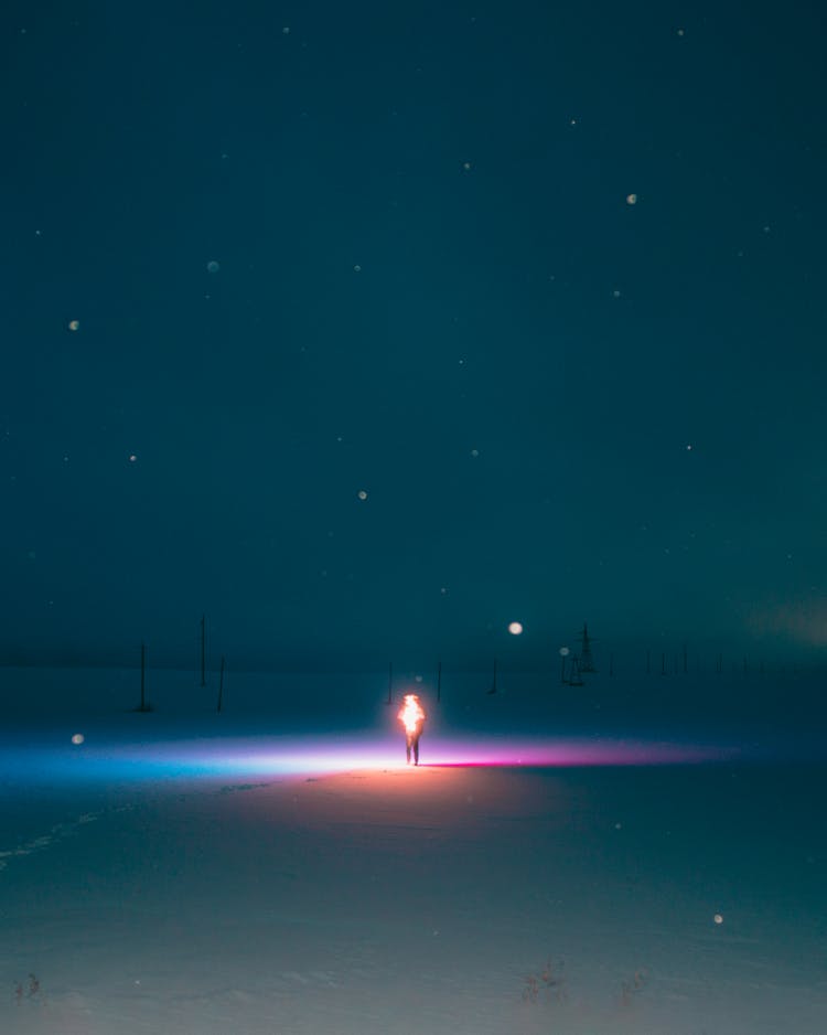 A Person Walking On Snow Covered Field