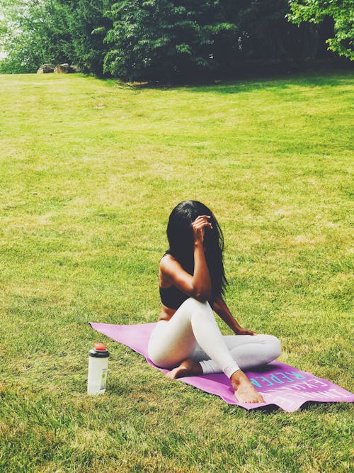 A Woman Doing Yoga on the Grass Field