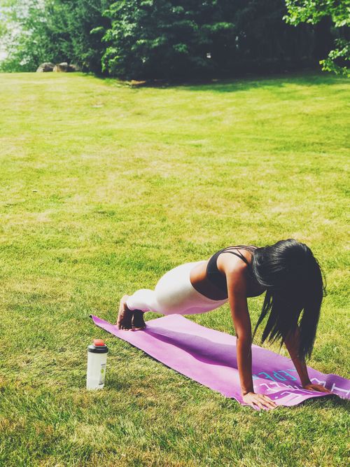 Free Woman practicing yoga outdoors on a sunny day, emphasizing a fit and healthy lifestyle. Stock Photo