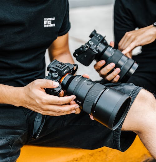 Free Two People holding Black Cameras  Stock Photo