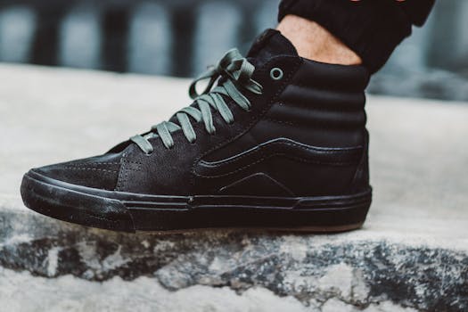 Stylish black high-top sneaker close-up on urban stone pavement.