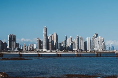 Free Panama City skyline with towering skyscrapers reflecting in the ocean under a clear blue sky. Stock Photo