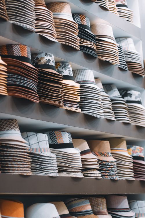 Free Vertical shot of stacked stylish hats on shelves in a boutique showcasing fashion variety. Stock Photo