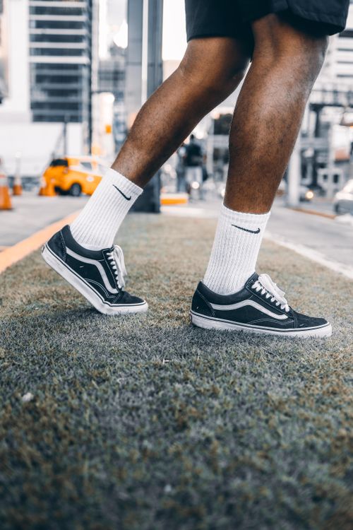 Free Close-up photo of a person walking in an urban setting wearing stylish sneakers and socks. Stock Photo