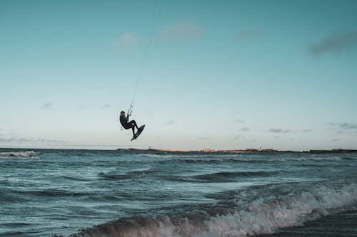 A Person Kitesurfing on the Beach