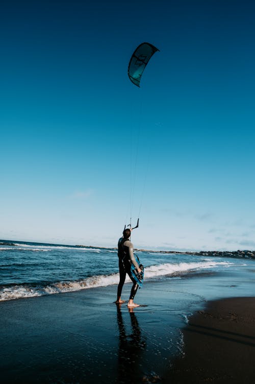 A Person Kitesurfing on the Beach