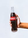 Man Holding a Cold Coca-Cola in a Glass Bottle 