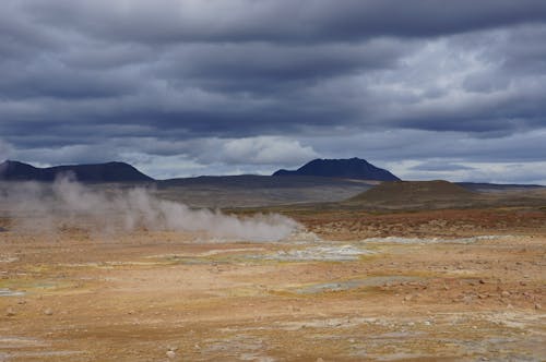 Brown Field Under the Cloudy Sky