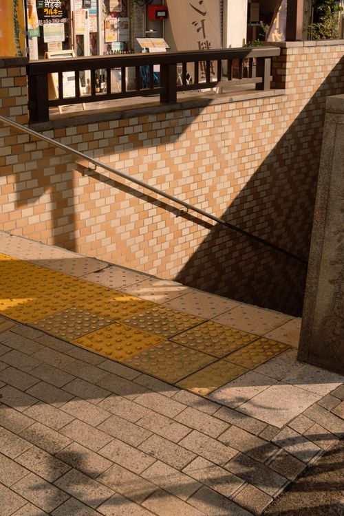 Free Urban entrance to a subway underpass with brick walls and shadows on a sunny day. Stock Photo