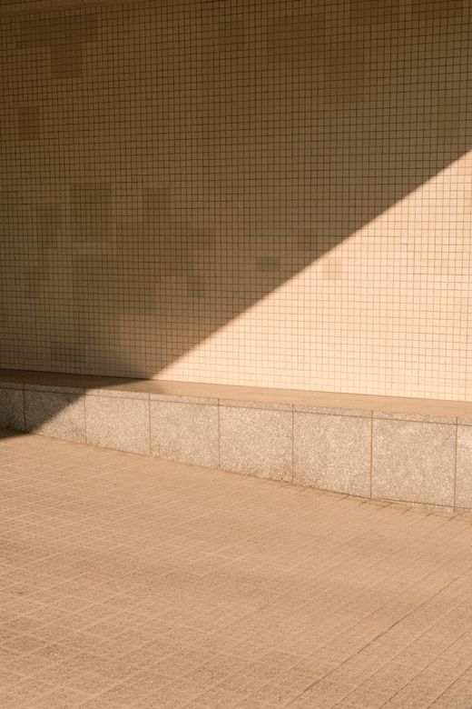 Shadow falling across a small-tiled wall — photo by Mak_ jp on Pexels