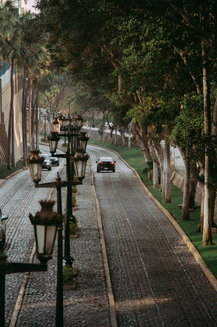 A picturesque cobblestone street with lamp posts and greenery in Miraflores, Peru.