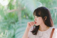 Woman Suck Thumb Finger Near Green Tree