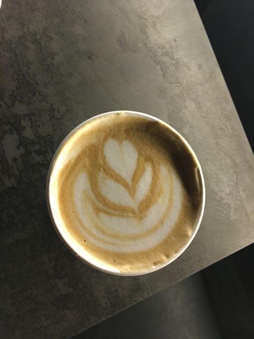 Free Close-up of intricate latte art in a coffee cup from a top-down view. Stock Photo