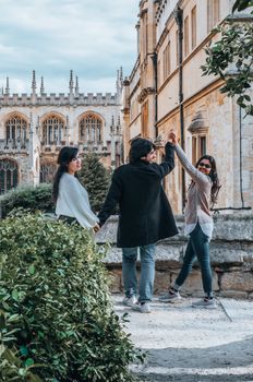 Three friends enjoying a sunny day at the historic streets of Oxford, England.