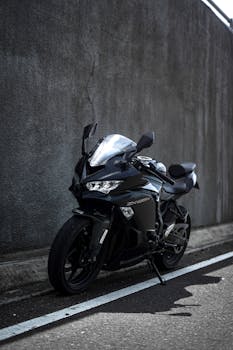 A stylish black sports motorcycle parked in an urban setting, showcasing modern design and sleek aesthetics.