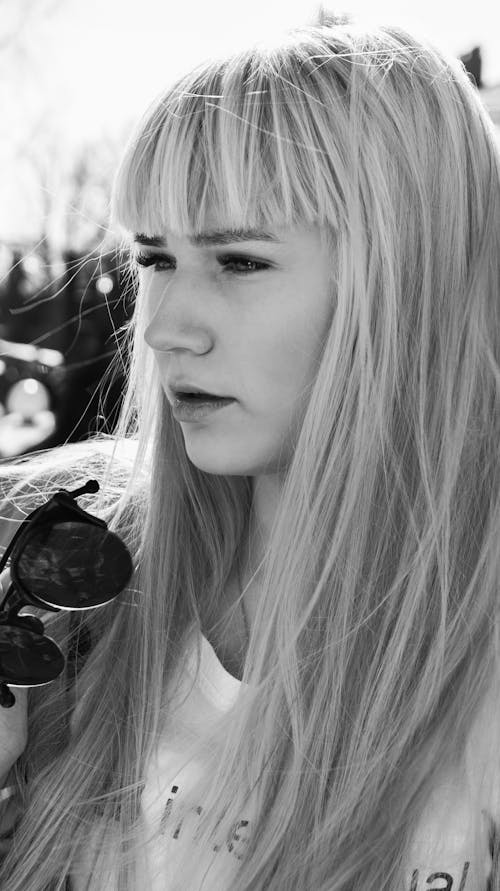 Gratis Fotografía En Blanco Y Negro De Una Mujer Sosteniendo Gafas De Sol Foto de stock