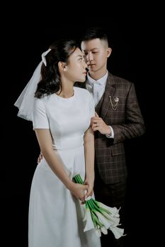 Stylish and intimate wedding portrait of an Asian couple in formal attire.