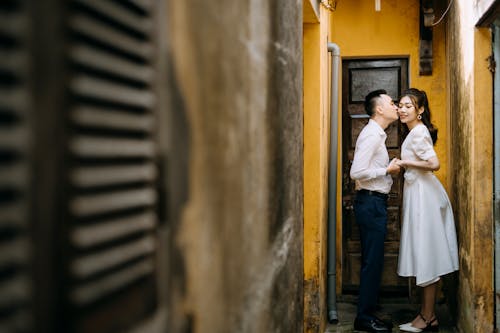 Newlywed Couple Kissing in Alleyway