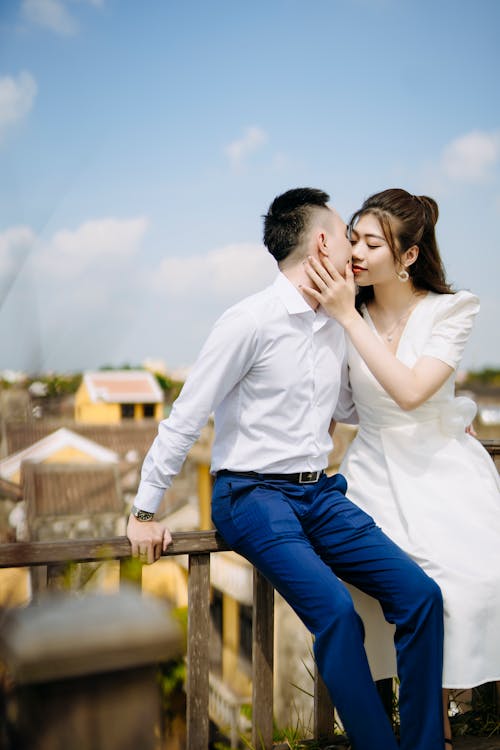 Free Newlywed Couple Kissing on Rooftop Stock Photo
