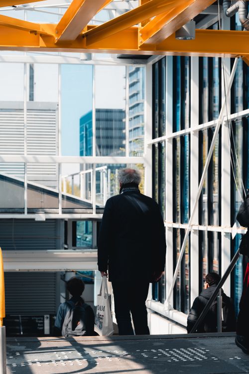 Free Elderly man with bag in modern Amsterdam setting, showcasing urban life. Stock Photo