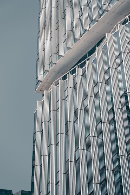 Free Low angle shot of a modern skyscraper showcasing a unique geometric facade pattern. Stock Photo