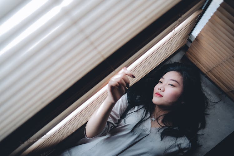 Woman Laying Beside A Window 