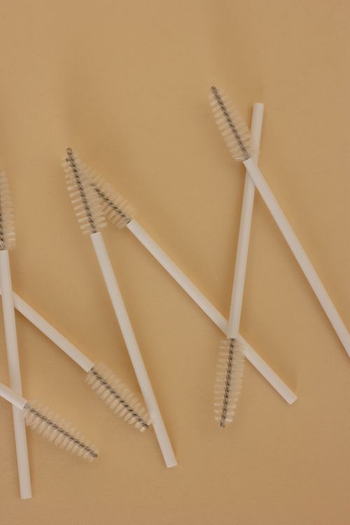 Free Flat lay of spoolie brushes for makeup application on a neutral background. Stock Photo