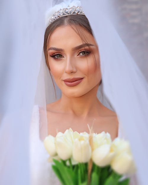 Woman in White Wedding Dress Holding White Flowers