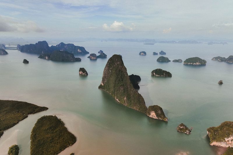 A breathtaking aerial view of lush green islands and calm seas under a cloudy sky.